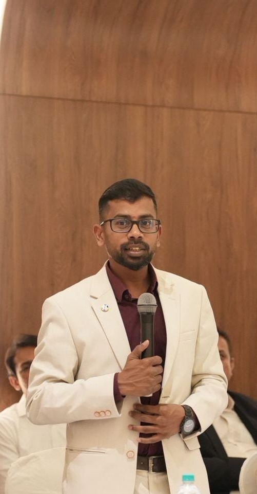 Vijay, founder of Grey Spatio, speaking into a microphone at an event